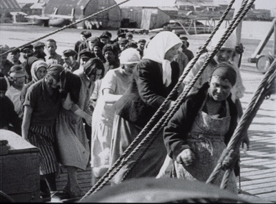 Russia, 1927-1928. Gruppo di donne che salgono sul piroscafo diretto alle Solovki. Fotogramma di un film di propaganda girato dalle autorità sovietiche 